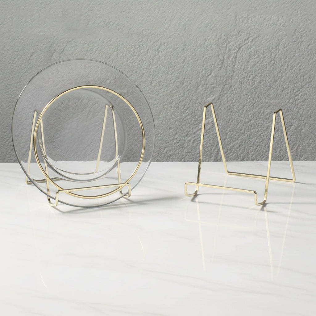 Set of gold metal plate stands on a white surface with a gray textured wall background