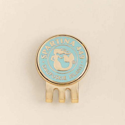 Round blue and gold object with 'Spartina 449' branding on a beige background
