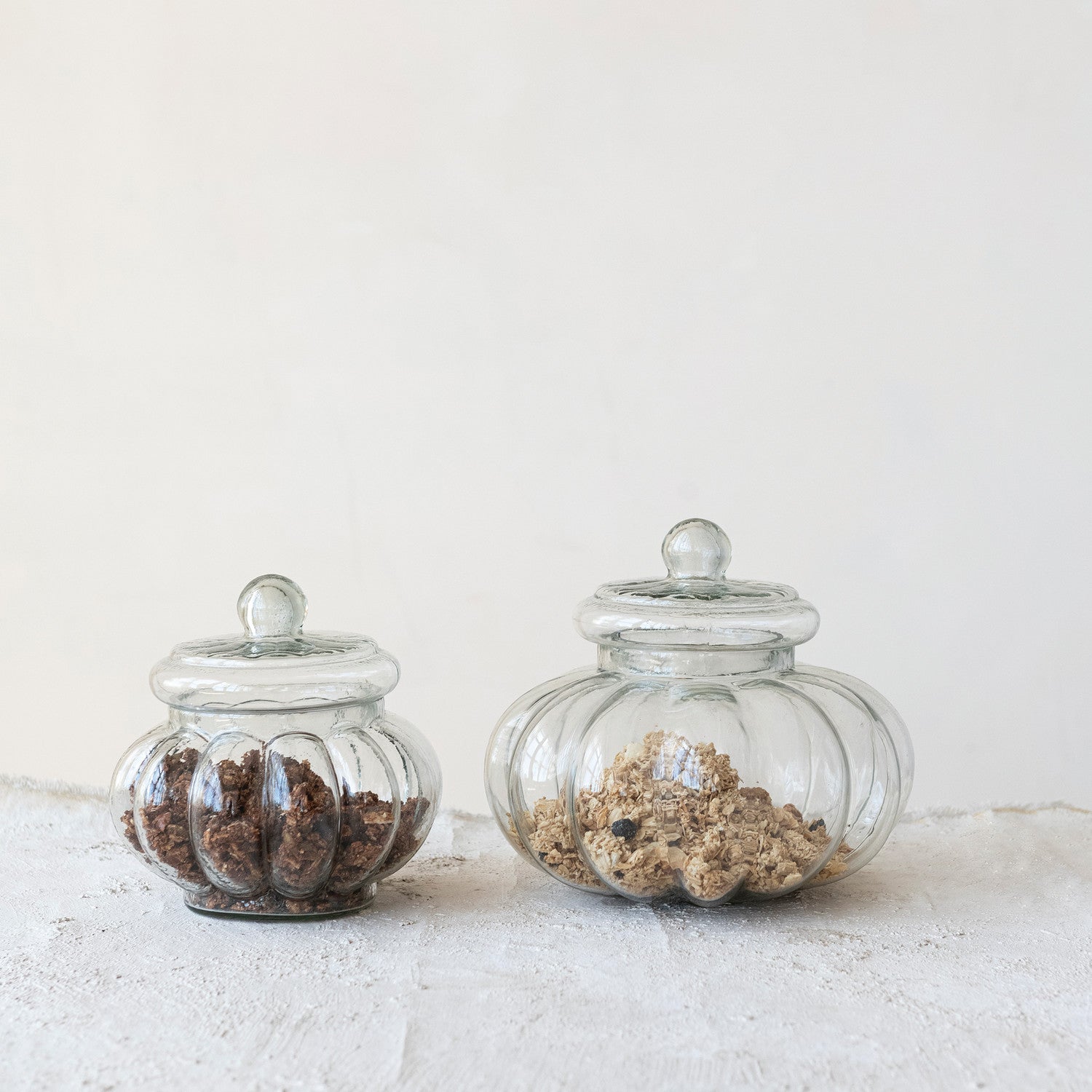 Two glass jars with decorative elements on a light background