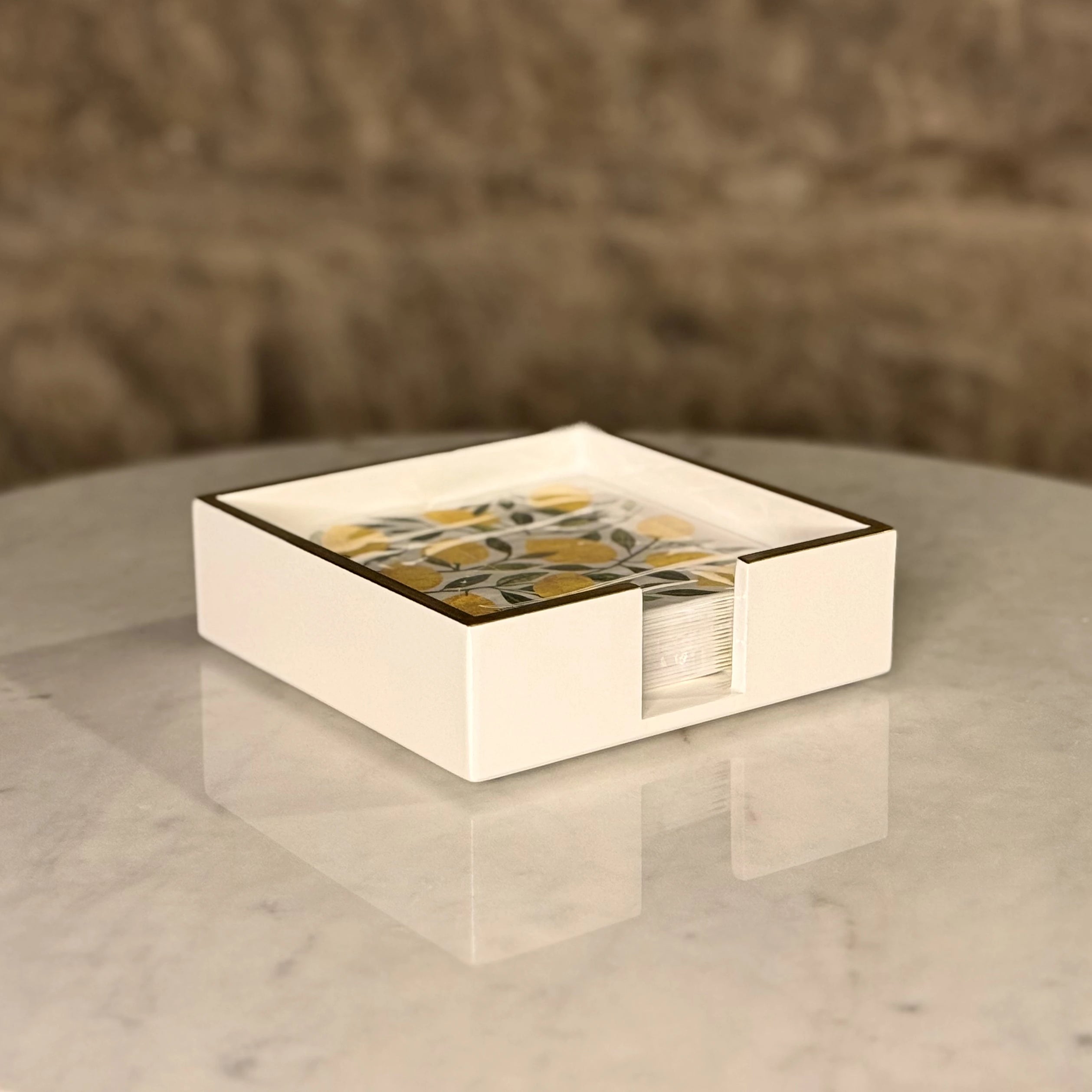 Square napkin holder with a decorative pattern on a marble surface