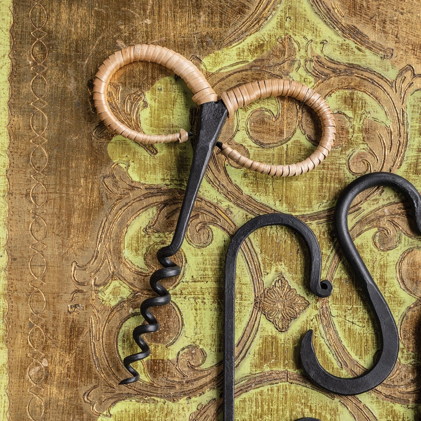 Decorative corkscrew and bottle opener on a textured background