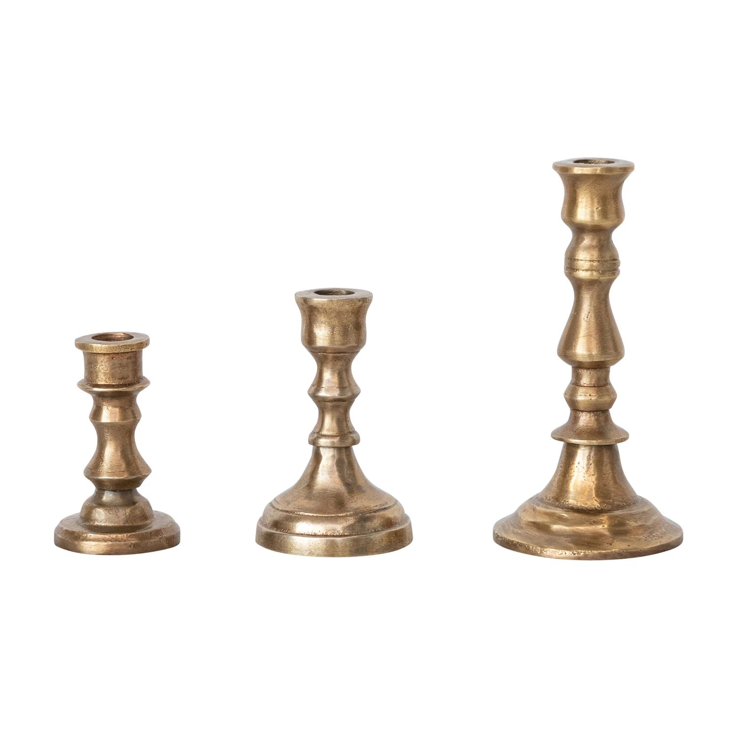Three brass candle holders of different sizes on a white background