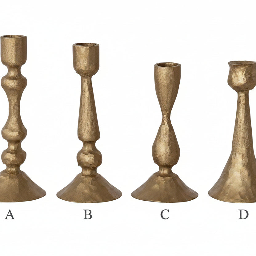 Set of four gold candle holders on a white background