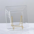 Clear acrylic stand with gold metal base on a light gray background