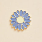 Blue flower-shaped pin on a beige background