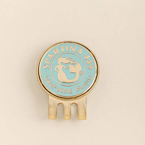 Round blue and gold object with 'Spartina 449' branding on a beige background