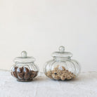 Two glass jars with decorative elements on a light background