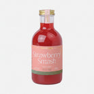 Bottle of strawberry smash cocktail mixer with a pink label on a white background