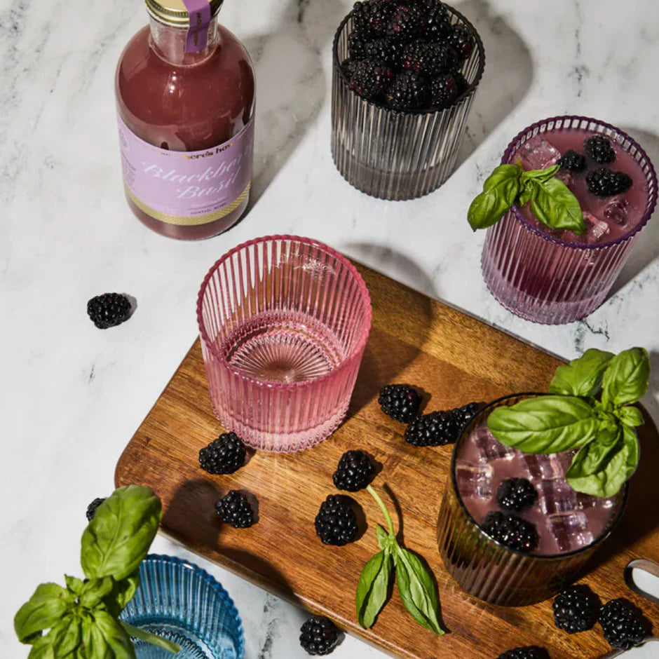 Blackberry lemonade with glasses and bottle on a marble surface