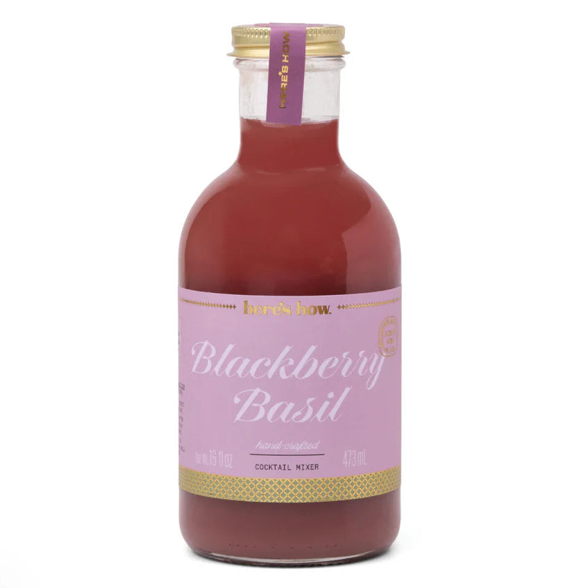 Bottle of blackberry basil cocktail mixer with a pink label on a white background