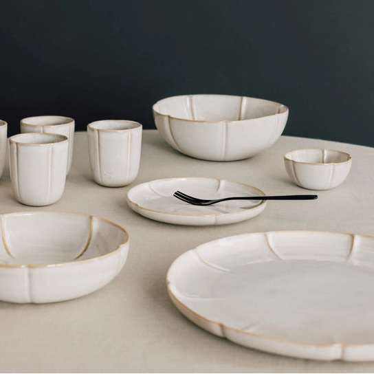 Set of ceramic dishes on a neutral surface with a dark background