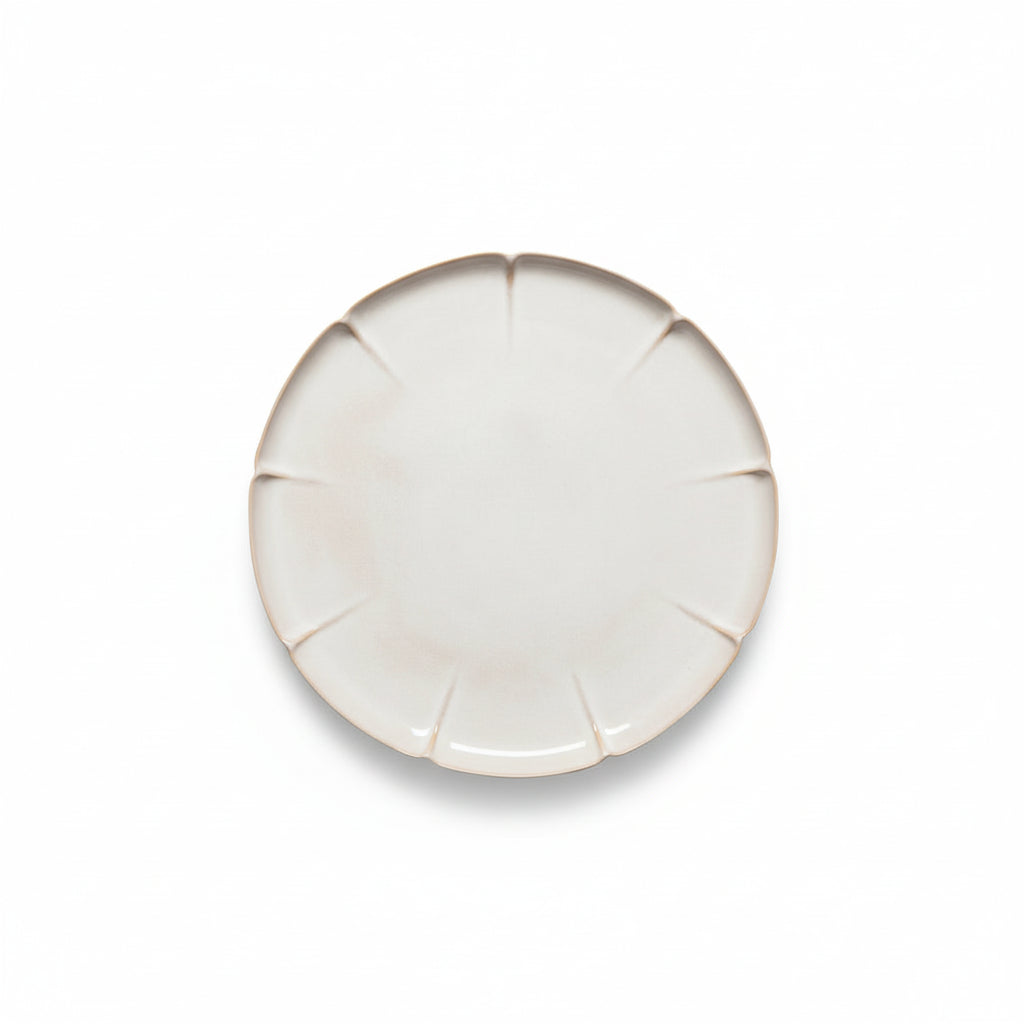 Round ceramic plate with a textured edge on a white background