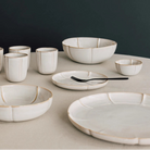 Set of ceramic dishes on a neutral surface with a dark background