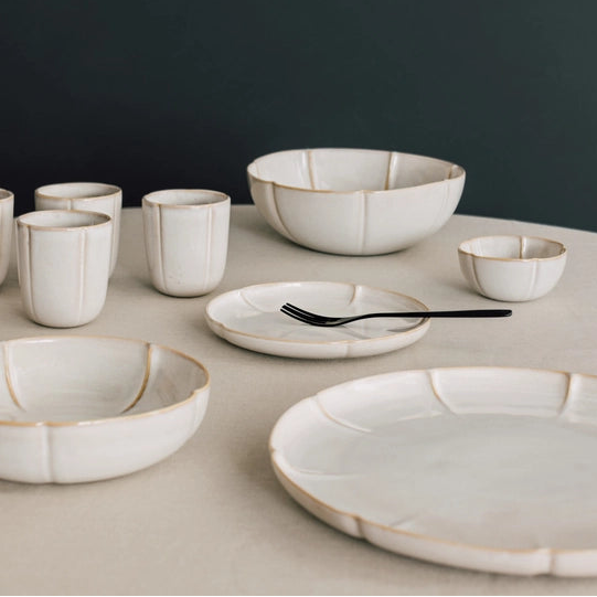 Set of ceramic dishes on a neutral surface with a dark background