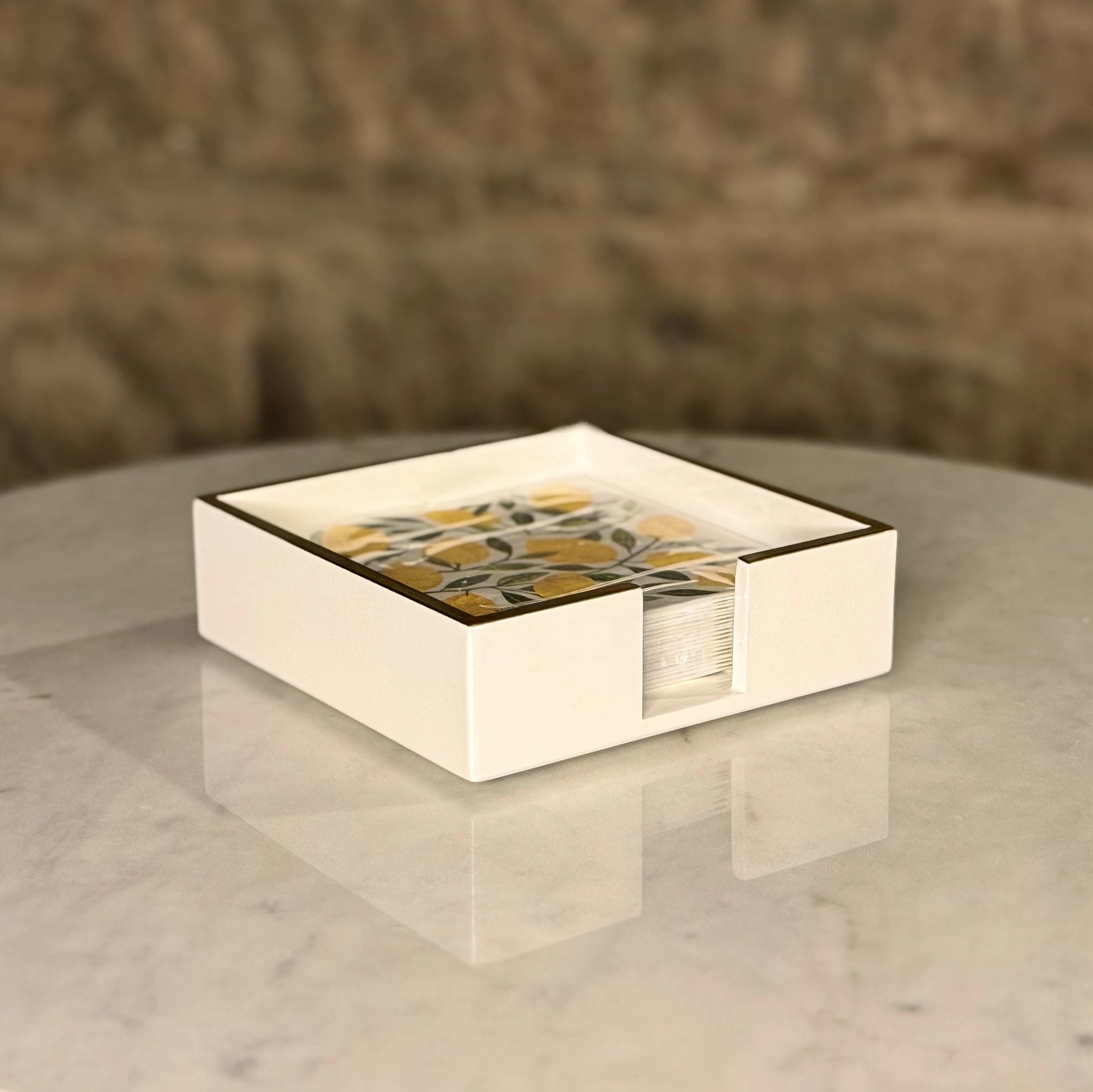 Square napkin holder with a decorative pattern on a marble surface