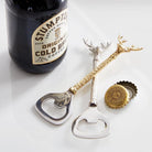 Bottle opener with antler design next to a bottle of Stumptown coffee on a white surface.