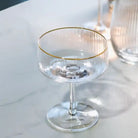Clear glass with gold rim on a white surface