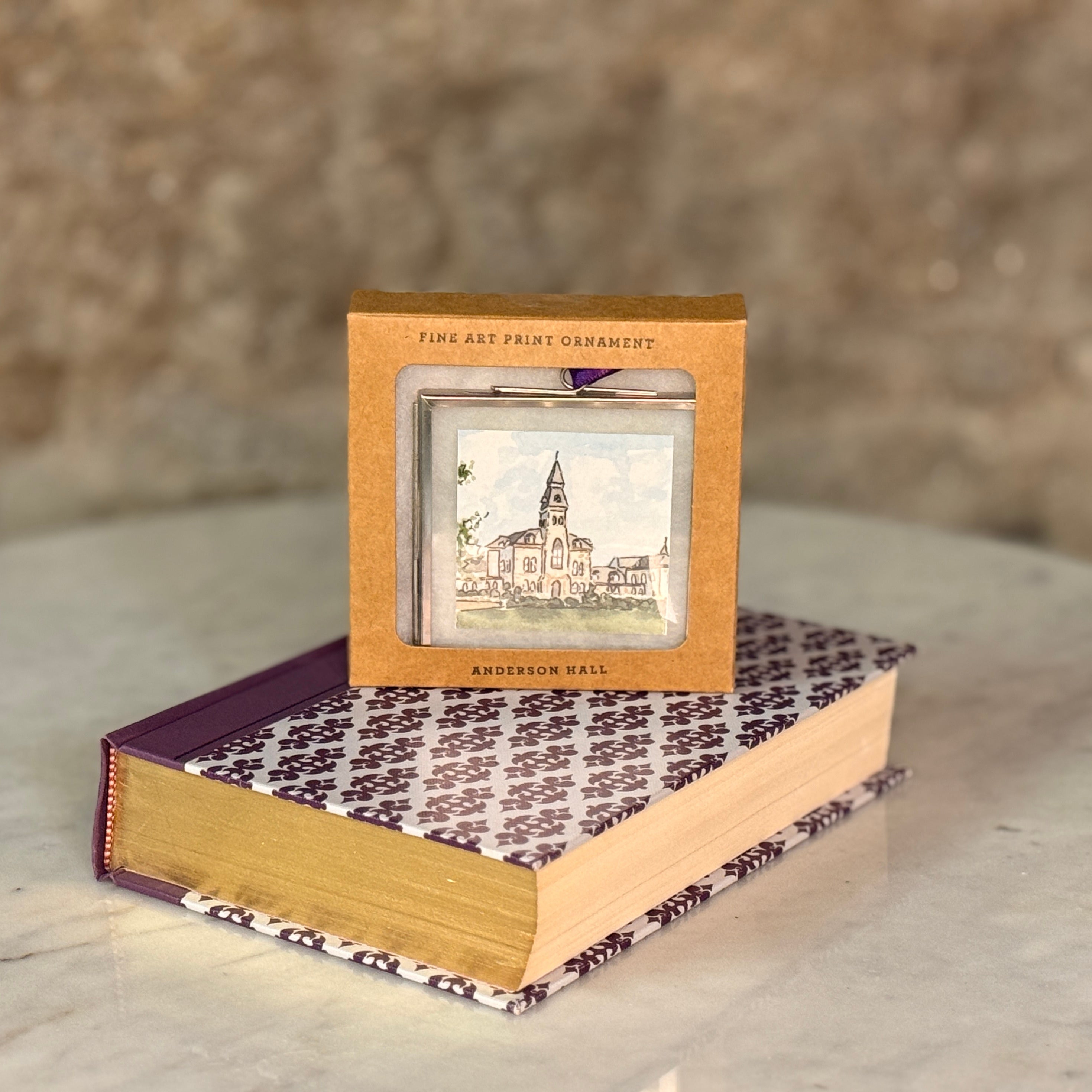 Decorative book with a small framed artwork on a marble surface