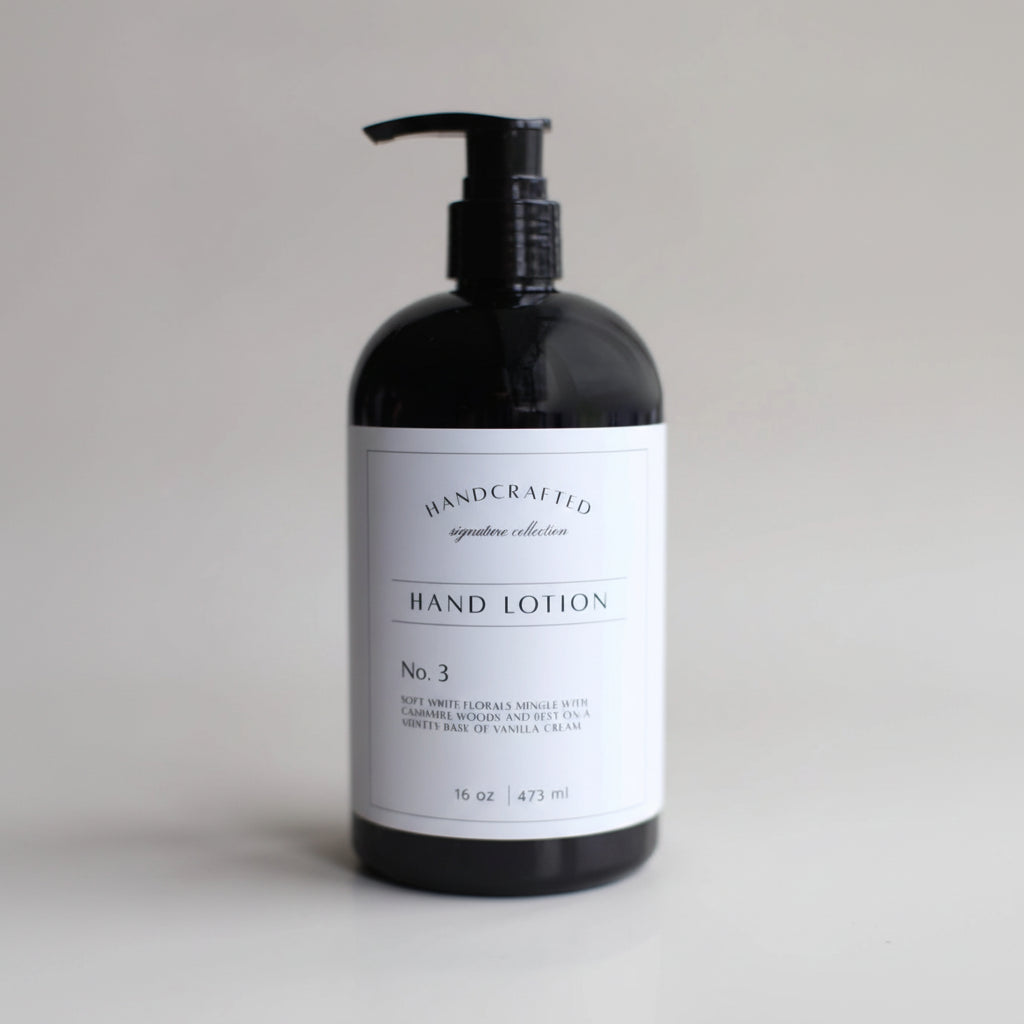 Black bottle of hand lotion with a white label on a light gray background