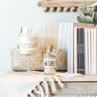 Decorative items on a shelf including books, a candle, and matches with a neutral background.