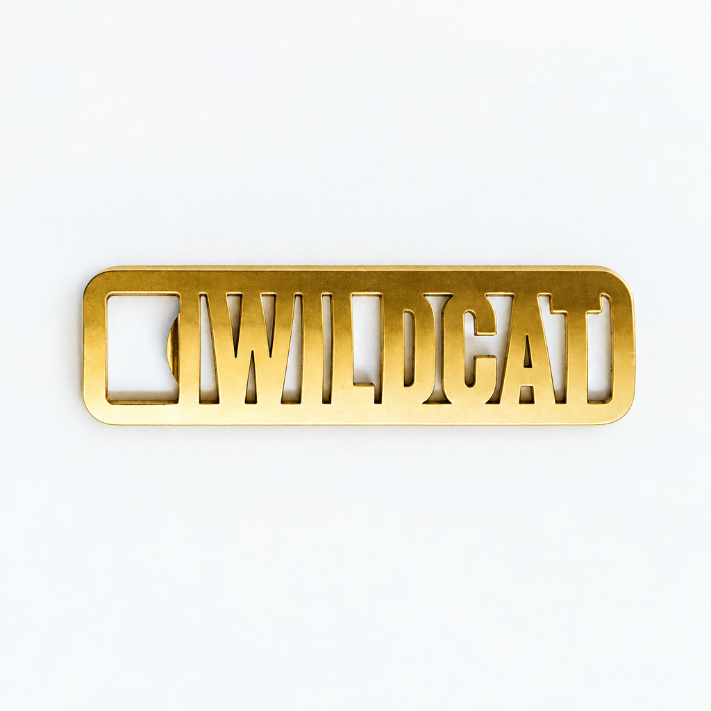 Gold metal nameplate with 'WILDCAT' engraved on a white background