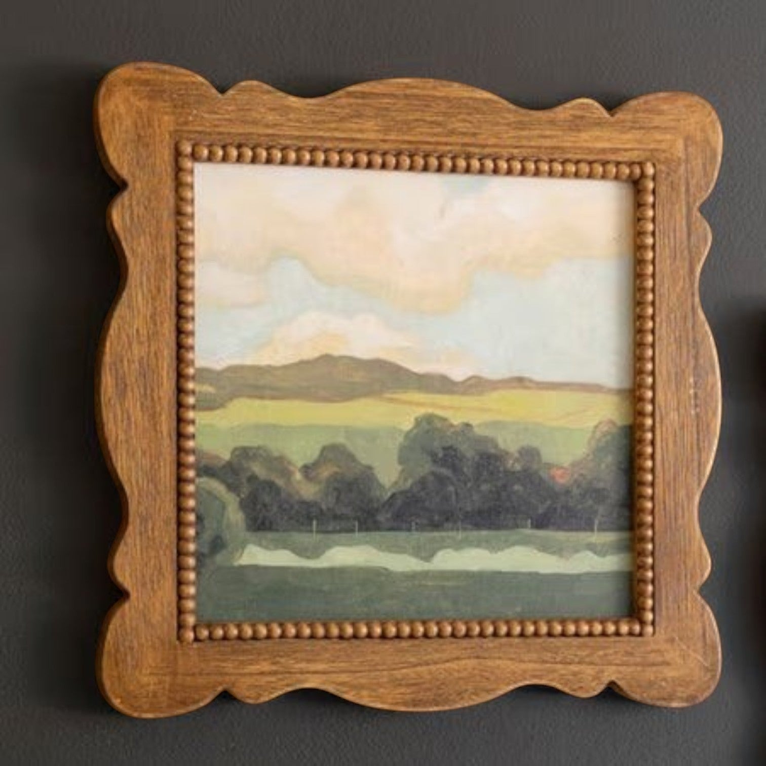 FurnishHere natural wood framed landscape painting with green hues and beaded edge detail.