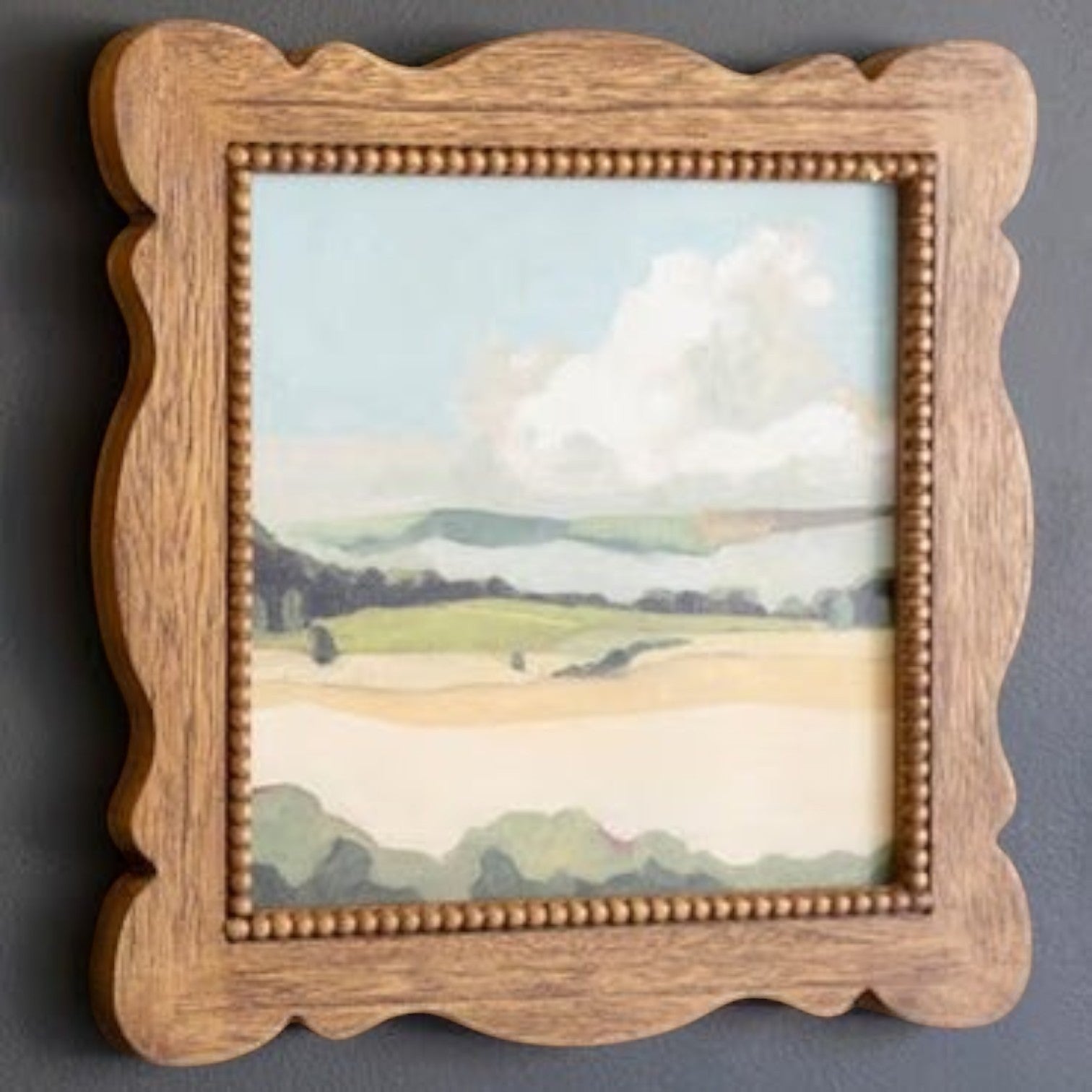 FurnishHere natural wood framed landscape acrylic painting with beaded edge detail and wavy frame. Features green hills and sky.