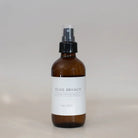 Brown spray bottle labeled 'OLIVE BRANCH' on a light gray background