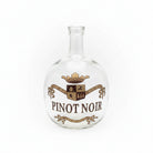 Clear glass bottle with 'Pinot Noir' label on a white background
